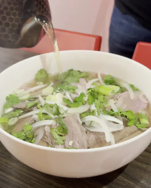 Caldo caliente servido sobre un tazón de phở